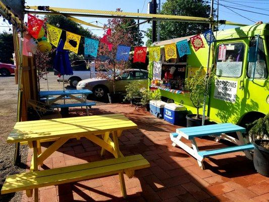 Outdoor seating area with a few more tables undercover behind the photo.