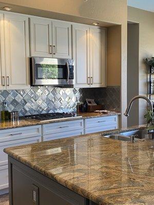 The new cabinets enhance the pewter backsplash.