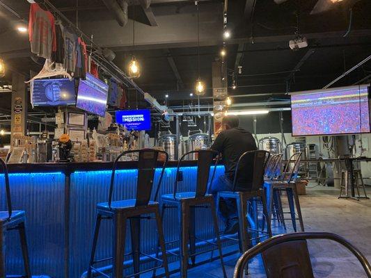 Half of the bar seating with one of the many projector screens