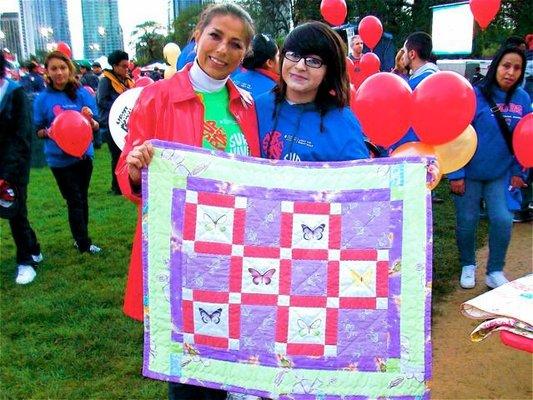 Francine gifting a fabric recycled quilt to a child