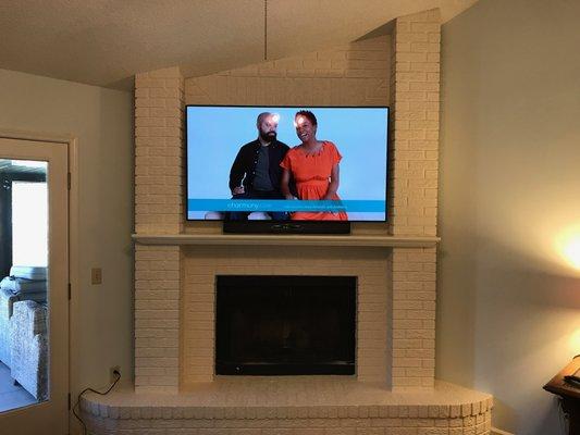 65" TV on articulating bracket mounted to brick.  All wires were run through attic to adjacent wall