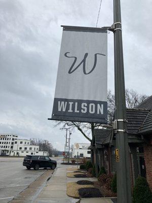 banner located along sidewalk between cafe and pharmacy