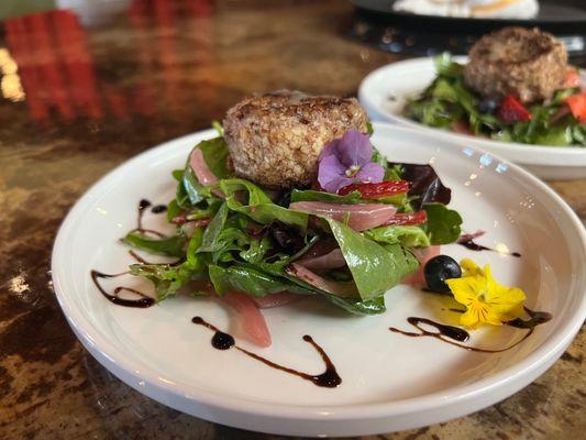 Pecan crusted goat cheese on greens with edible flowers