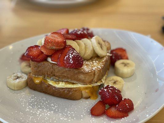 Sausage egg and cheese Texas French Toast with strawberries and bananas