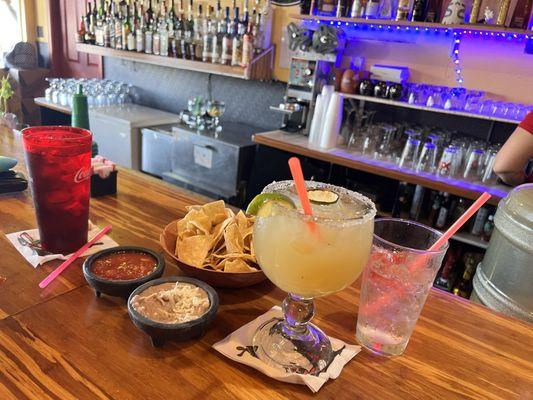 Massive margarita served with chips, beans, and salsa