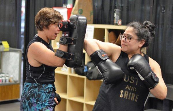 Victoria lands a spinning elbow on the thai pads