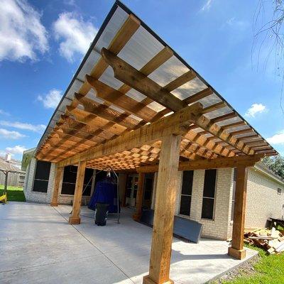 Custom cedar pergola build with bronze premium system to protect from weather.