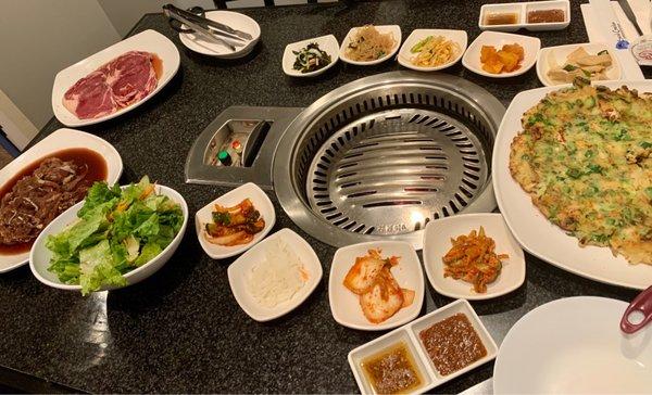 Steak, Bulgogi, salad, side dishes (kimchi green onion, pickled radish, kimchi, fish cake), dipping sauce, Haemul Gochu Pajun