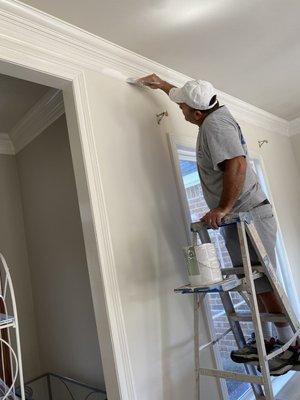 Painting the crown molding with some white semi gloss paint to give it that brand new look.