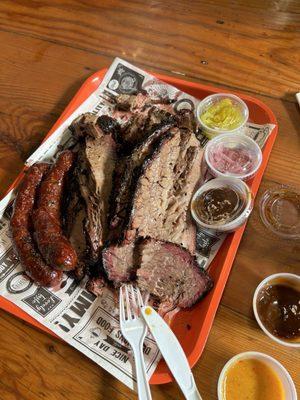 Beef Brisket, beef jalapeño sausages, and homemade bbq sauces with pickled sides.