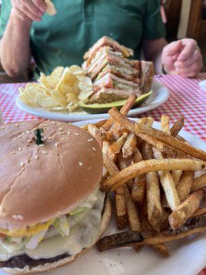 Club sandwich with chips and hot pepper cheeseburger with fries.