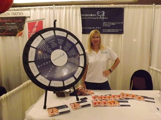 Dr. Szyperski inviting brides at the Bridal Show to "spin to win"!