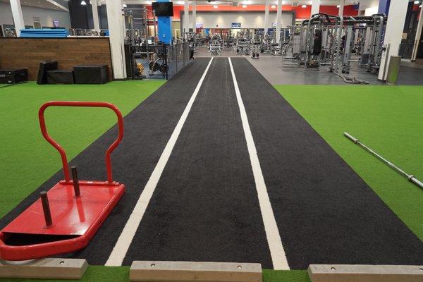 The turf area at our East Harry location provides you with lots of equipment to stretch and workout. Ready to test the sled push?