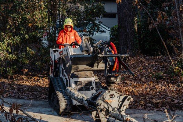 Operating our mini skid steer carefully over plywood to make sure customers property is not damaged.