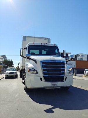 Crest truck parked on the middle of the street blocking traffic and an active driveway