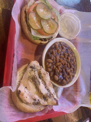 Grilled chicken sandwich and baked beans.