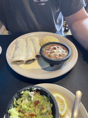 Ground beef enchiladas with queso, pintos, rice, guacamole