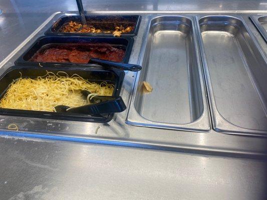 Half empty salad bar with dried up pasta