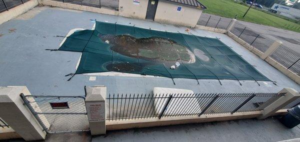 Trash on pool cover old dirty mattress beside it with broken chair