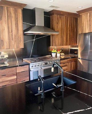 Modern kitchen design with walnut cabinets and black quartz countertops