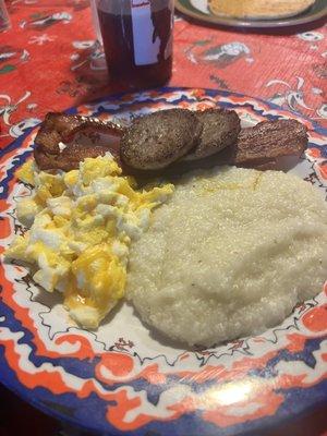 Scrambled eggs, grits, bacon and sausage