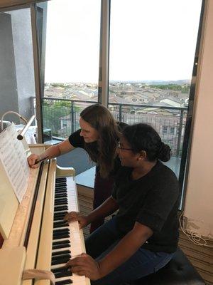 Writing in fingering at a piano lesson.