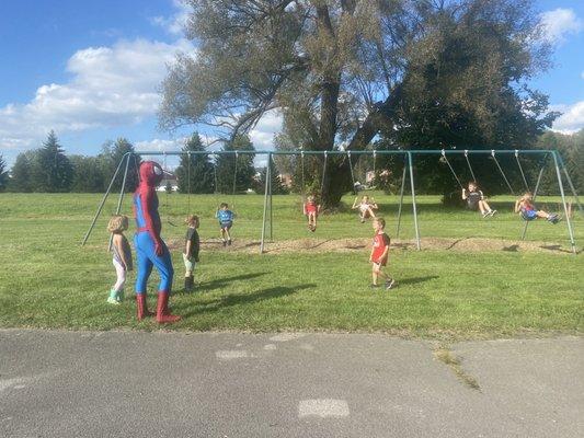 Spiderman hanging with our littles on the swings during our family picnic!