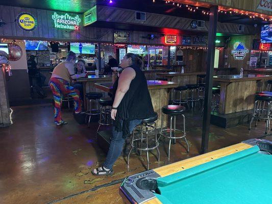 At the pool table facing bar. Karaoke on the left wall.