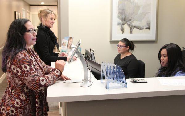 Our front desk helping patients check in and schedule appointments