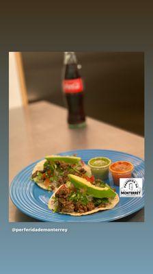 Fajita tacos on corn tortilla with pico and avocado slices.