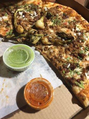 Carnitas pizza with red and green salsas add the perfect amount of flavor and heat.