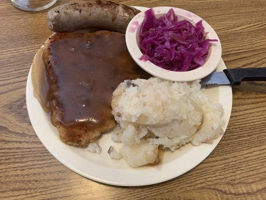 Schnitzel, sausage, German potato salad and red cabbage