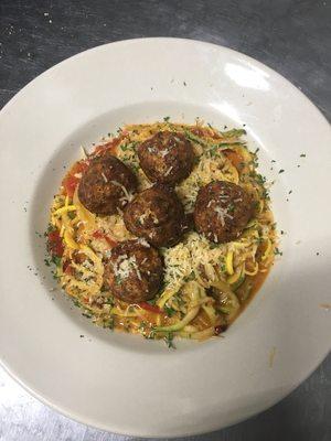 Garlic chicken meatballs over zucchini and yellow squash noodles with a garlic red sauce