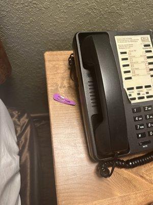 A hair clip left on nightstand by the phone - not ours