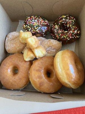 Glazed and sugar donuts, donut holes and chocolate cake sprinkled donuts.