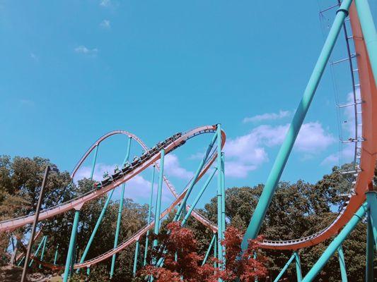 With orange track and teal blue supports, this 4/5ths of a mile long coaster features some great fan turns!