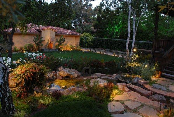 Backyard garden pond with outdoor lighting