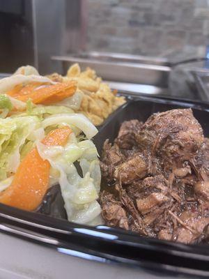 Jerk pork platter with steamed carrots and cabbage.