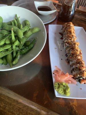 Edamame appetizer and a spicy crab topped roll