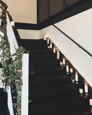 Stairwell installments and candles make for a cohesive and stunning design concept for those multiple-floor, indoor venues