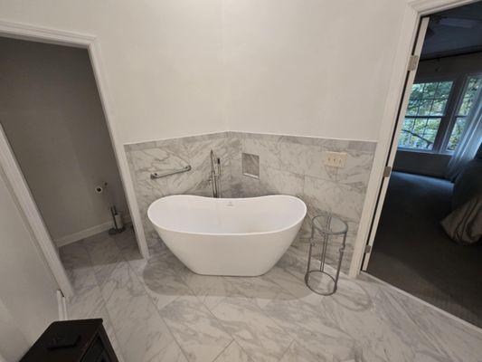 Installation of a luxury tub, free standing faucet and custom tile floor and backsplash. Peep the toilet room.