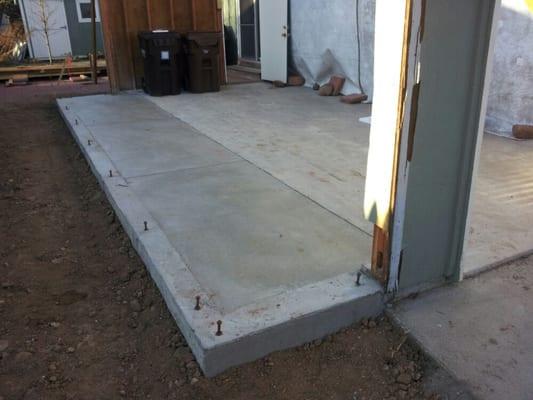 Pad extension with footer and leveled to grade plate lip to extend garage for new room.