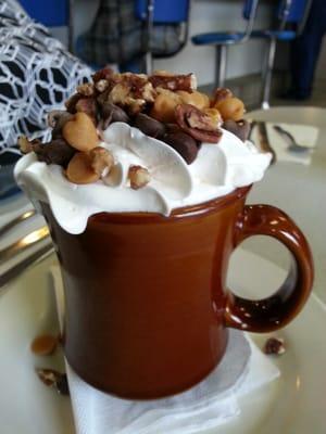 Hot chocolate with whipped cream, chocolate chips, peanut butter, and pecans.