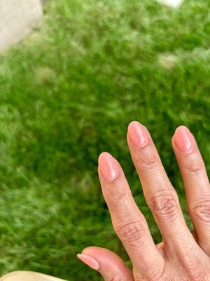 hand with shiny light coral nails in almond shape