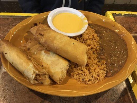 Chicken flautas with queso, beans and rice.