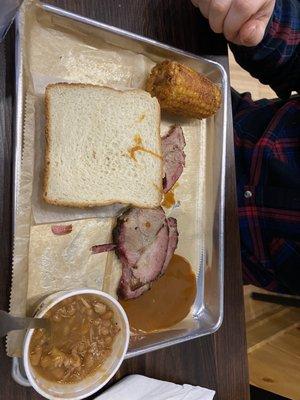 The bbq plate he ordered with 1/2 of corn on the cob and baked beans