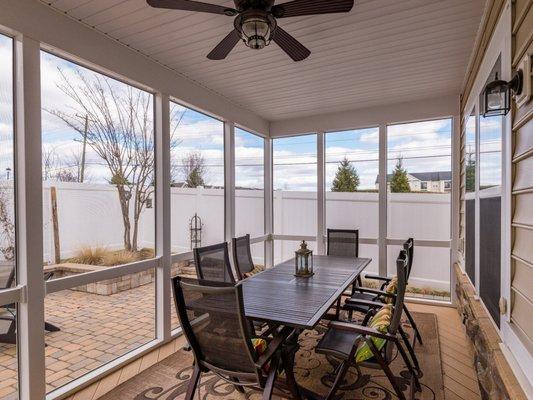 Screened in porch with fenced in backyard.