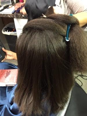 Straightening her hair