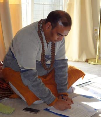 Reiki Raja Yoga Grandmaster Shailesh signing manuals.