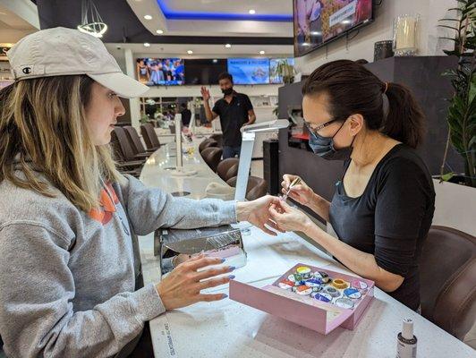 Tina working hard on my daughter's powder nails